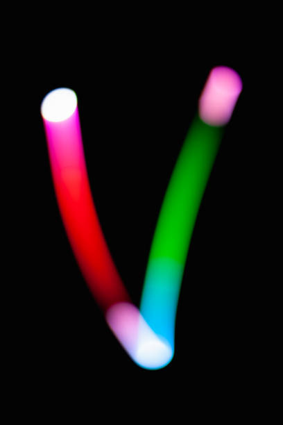 istock Letter V. Glowing letters on dark background. Abstract light painting at night. Creative artistic colorful bokeh. New Year. Use it for build you own design for book cover, CD, poster or post card. 1031481806