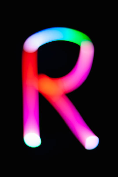 istock Letter R. Glowing letters on dark background. Abstract light painting at night. Creative artistic colorful bokeh. New Year. Use it for build you own design for book cover, CD, poster or post card. 1031481828