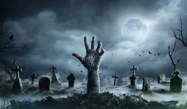 Buried Zombie Rising Out Of Ground In Misty Cemetery