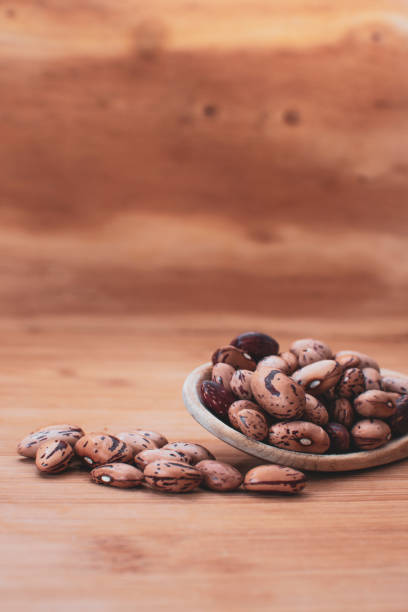 istock Pinto beans on wooden background on wooden spoon 1031489666