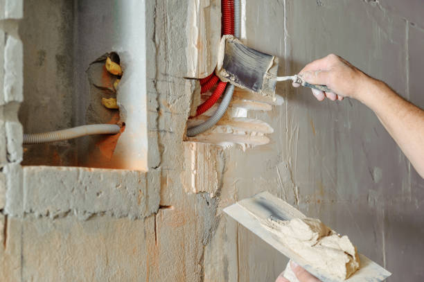 istock A worker is plastering the electric corrugated tubes in the wall. 1031493268