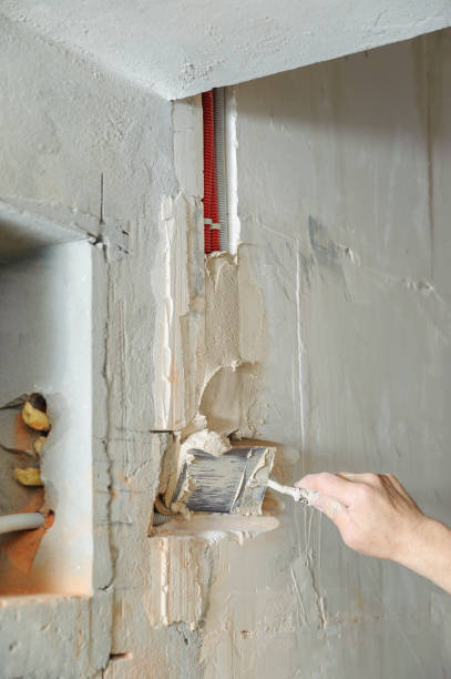 istock A worker is plastering the electric corrugated tubes in the wall. 1031493274