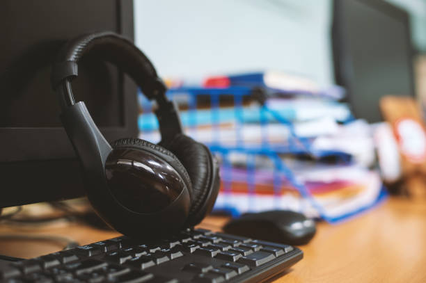 istock closeup headphones on desktop computer in office with soft-focus and over light in the background 1031493554