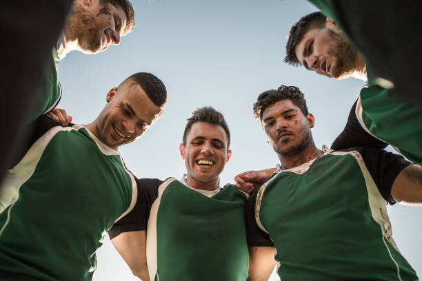 Rugby team in huddle after the match Low angle view of rugby players standing against clear sky. Rugby team in huddle after the match. rugby team stock pictures, royalty-free photos & images