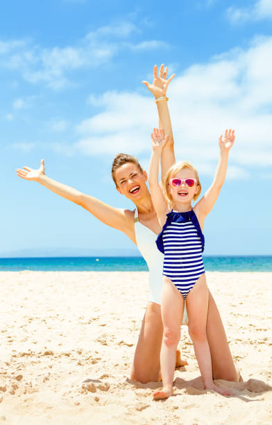 istock happy young mother and daughter on seashore rejoicing 1031508076