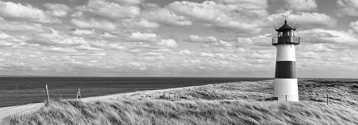 Sand dunes with lighthouse at Ellenbogen on island Sylt, Schleswig-Holstein, Germany. Black and white development (RGB-file)