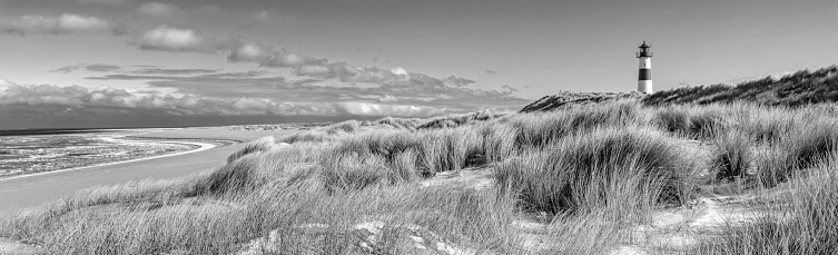 Sand dunes with lighthouse at Ellenbogen on island Sylt, Schleswig-Holstein, Germany. Black and white development (RGB-file)