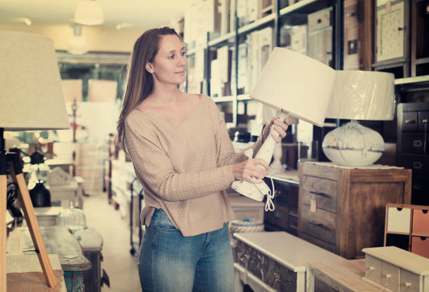 istock Woman looking for table lamp in shop 1031512198