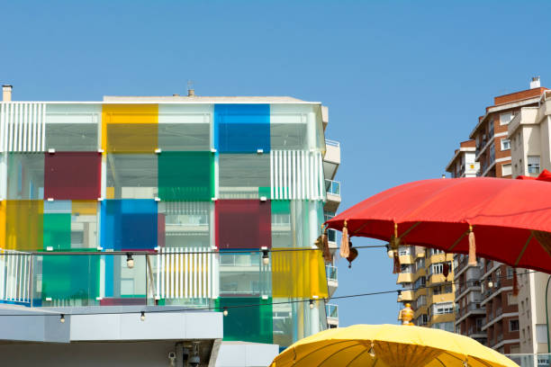 istock Two colored umbrellas with clolor building 1031515504