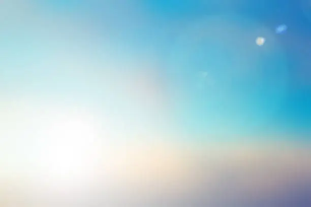 Photo of blurred beautiful natural morning sky in pastel tone color background with lens ray flare flash light.
