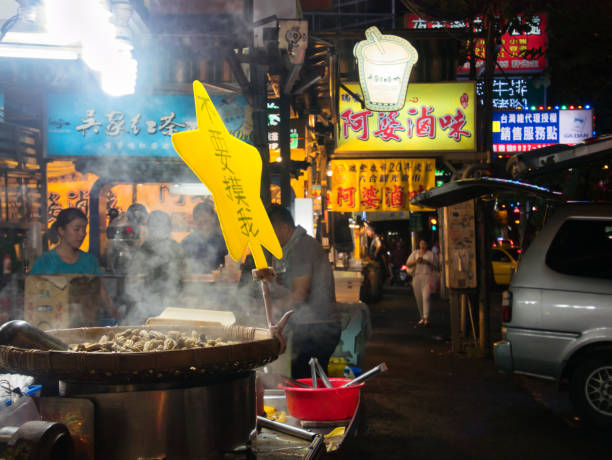 Peanuts being roasted in a hot, steaming big pan at the taiwanese night market Rui Feng in Kaohsiung, Taiwan