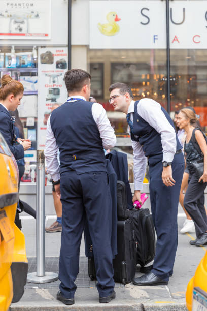 Hotel staff in New York city street New York, August 18, 2018:Hotel staff in New York city street. All kinds of staff like porters, waitress, maids and receptionists. People in uniform. airport porter stock pictures, royalty-free photos & images