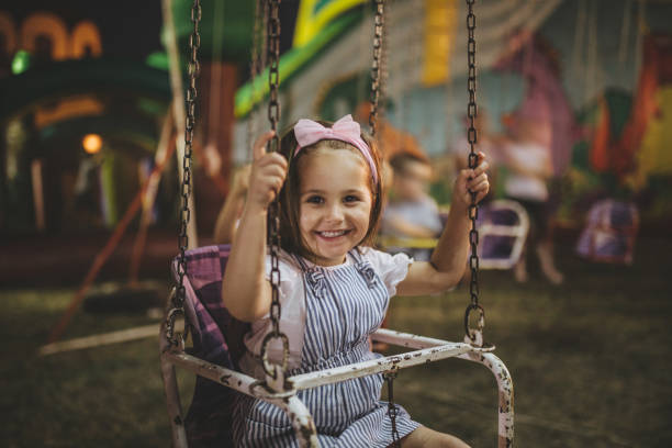 istock Lovely child enjoying her ride on a merry go round 1031535144