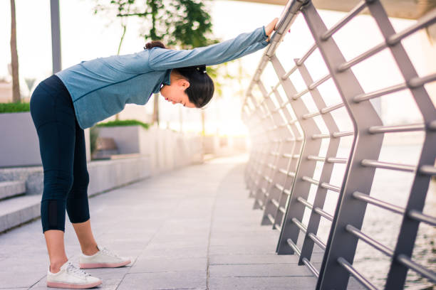 istock Girl stretching before running in urban environment 1031535580