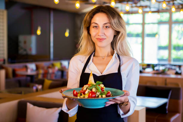 istock Pretty barmaid holding plates of salads 1031544836