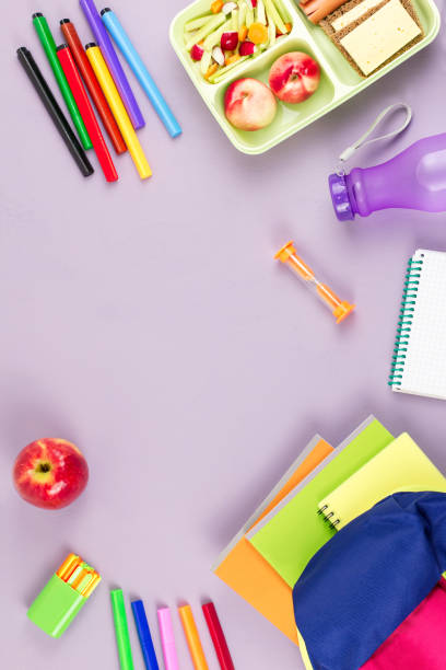 istock School concept flat lay. Kid backpack, lunchbox, water bottle, notebook, markers on wooden desktop 1031551254