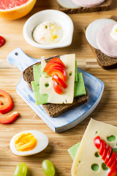 istock Breakfast table with cheese sandwiches, sausage, vegetables, hard boiled eggs and fruits 1031551402