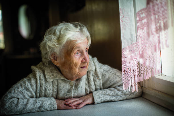 istock Gray-haired elderly woman sits and looks out the window. 1031551742