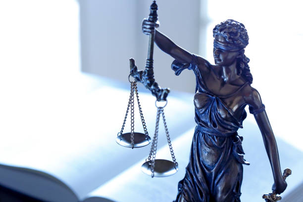 istock Lady Justice Statue In Front Of Open Law Book 1031552024
