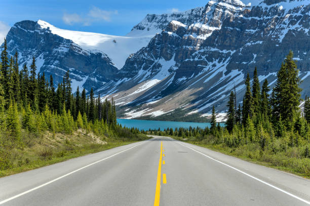 icefields parkway a bow lake - una vista primaverile serale di icefields parkway che si estende verso bow lake, con bowcrow peak, crowfoot glacier e crowfoot mountain che si innalzano in alto dietro, banff national park, ab, canada. - autostrada a due corsie foto e immagini stock