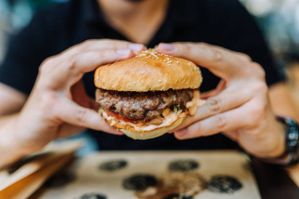 istock Eating tasty hamburger. Close-up. 1031561162