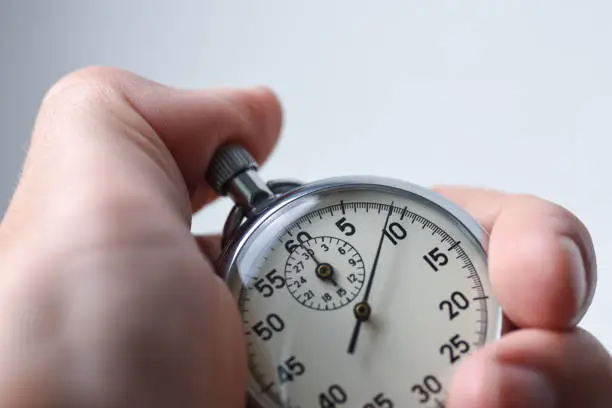 Close-up of an isolated hand presses the stopwatch start button in the sport, measurements, metrology
