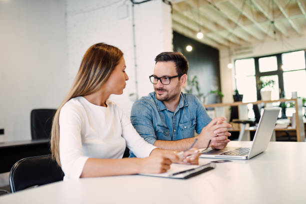 istock Two coworkers talking in at modern open space office. 1031563434