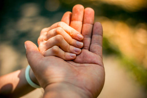istock Close up of two hands holding together 1031563582