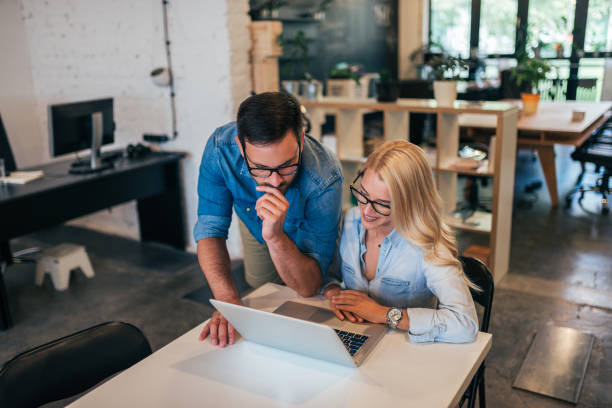 istock Confident young man and woman working together in creative office. 1031563588