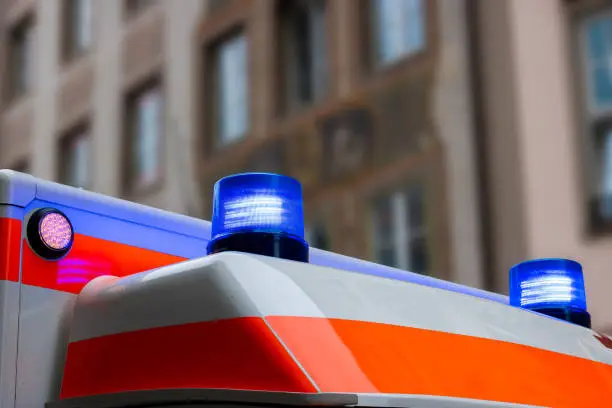 A german ambulance car with flashing blue lights in an urban area