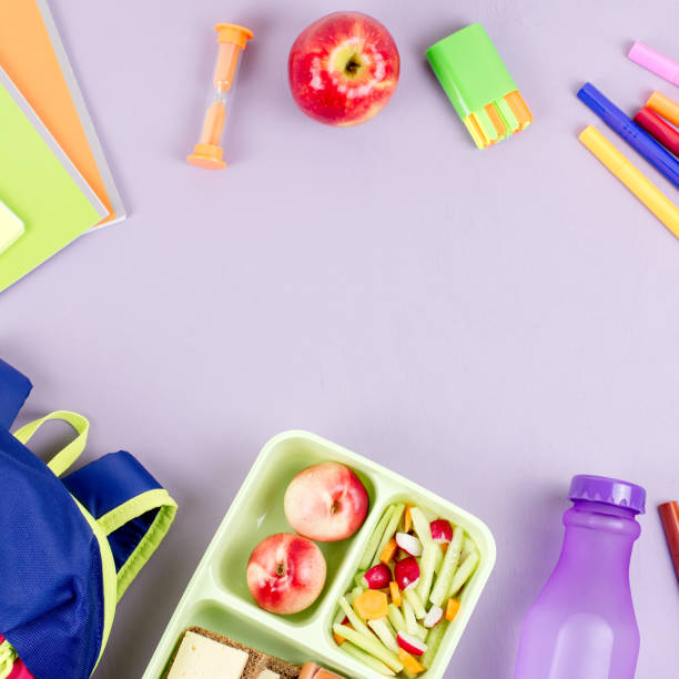 istock School concept flat lay. Kid backpack, lunchbox, water bottle, notebook, markers on wooden desktop 1031576616