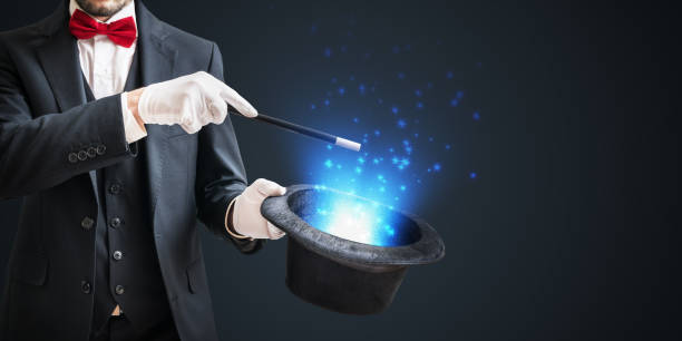 istock Magician or illusionist is showing magic trick with wand and hat on dark background. 1031587416
