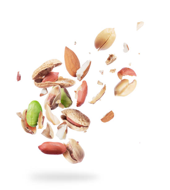 Various nuts crushed in the air, isolated on white background Various nuts crushed in the air, isolated on white background almond slivers stock pictures, royalty-free photos & images