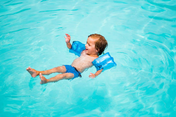 bambino di bellezza che galleggia in piscina - arm band foto e immagini stock