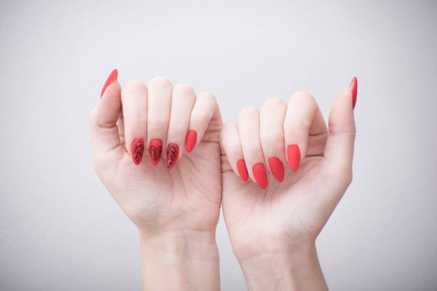 istock Red manicure with a pattern. Female hands on a white background 1031606588