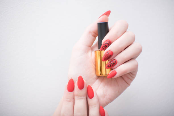 istock Red manicure with a pattern. Vial with nail polish 1031606622