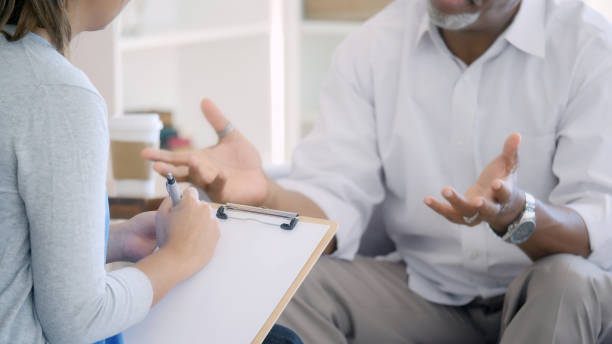 istock Senior man discusses problems with mental health professional 1031623362