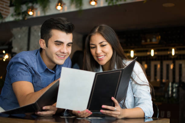 istock Couple at a bar looking at the drinks menu very happy 1031628832