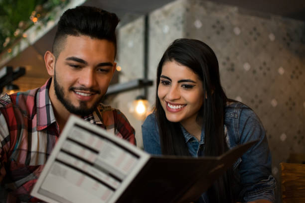 istock Beautiful couple looking at the menu smiling 1031628956