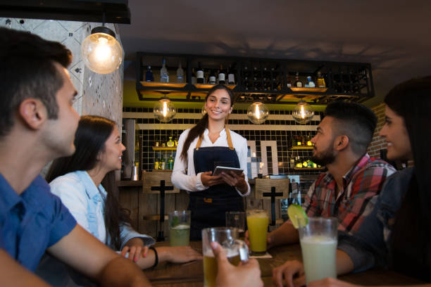 istock Friendly waitress taking an order from a group of friends at a bar 1031628978