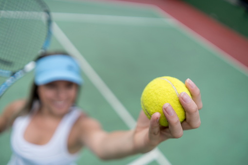 Unrecognizable woman playing tennis ready to serve  - Focus on foreground