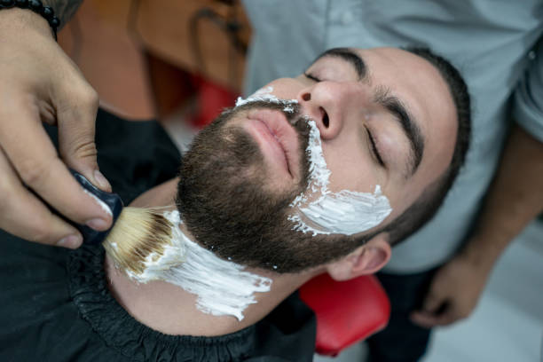 istock Unrecognizable barber putting shaving cream on a customer to shave his beard 1031633270
