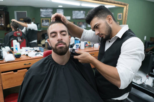 istock Professional barber trimming a customers beard with an electric razor 1031633374