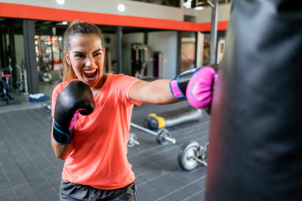 istock Energized woman punching boxing bag with all her rage 1031633476