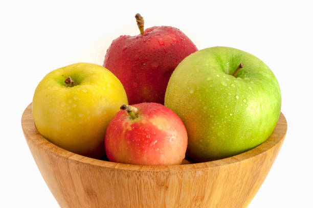 istock Apples in wooden bowl isolated on white background 1031634780