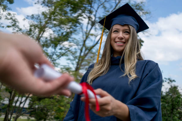 istock Beautiful student graduating from high school receiving diploma looking very happy 1031634900