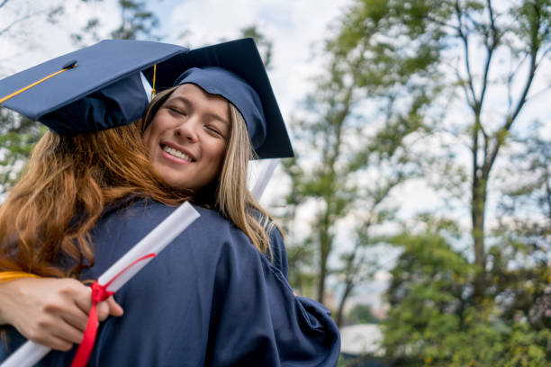 istock College friends hugging on graduation day looking excited 1031634928
