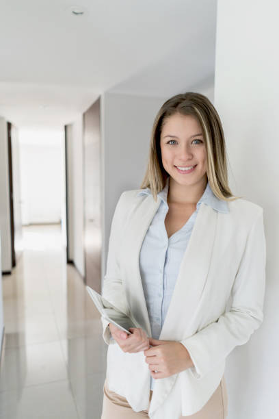 istock Latin american friendly real estate agent at a property looking at camera smiling 1031635372