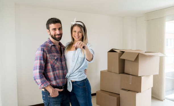 istock Loving man hugging his partner while she holds the keys to their new place looking at camera smiling 1031635450