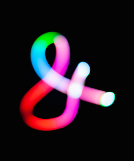 Glowing ampersand symbol & logogram on dark background. Abstract night light painting. Creative artistic colorful bokeh. New Year. Use  to build you own design for book cover, CD poster or post card Glowing ampersand symbol & logogram on dark background. Abstract night light painting. Creative artistic colorful bokeh. New Year. Use  to build you own design for book cover, CD poster or post card long shutter speed stock pictures, royalty-free photos & images